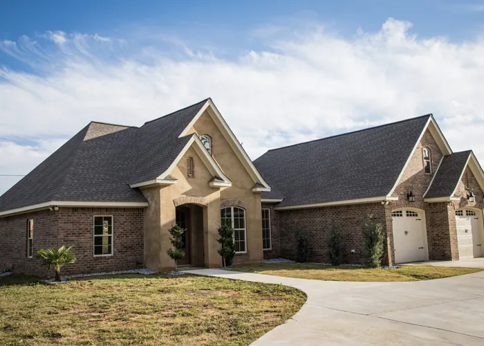 Brick and stucco home with an arched front entry and side-entry garage