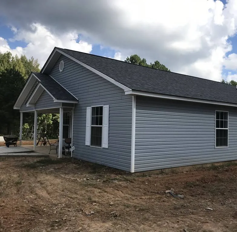 New gray-sided home with a gabled covered porch