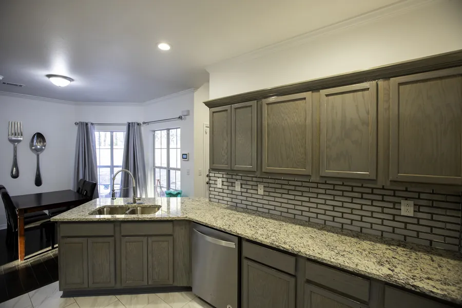 Kitchen with gray-stained cabinets, granite countertops, a subway-tile backsplash and a breakfast nook with tall windows